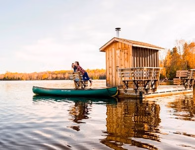 Floating sauna with two woman looking at Kawawaymog Lake