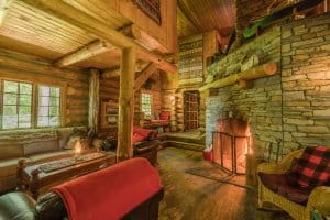 Algonquin Log Cabin with wooden furniture and on the right a big fireplace