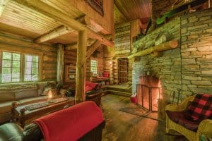 Algonquin Log Cabin with wooden furniture and on the right a big fireplace