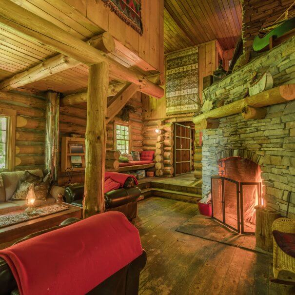 Algonquin Log Cabin with wooden furniture and on the right a big fireplace
