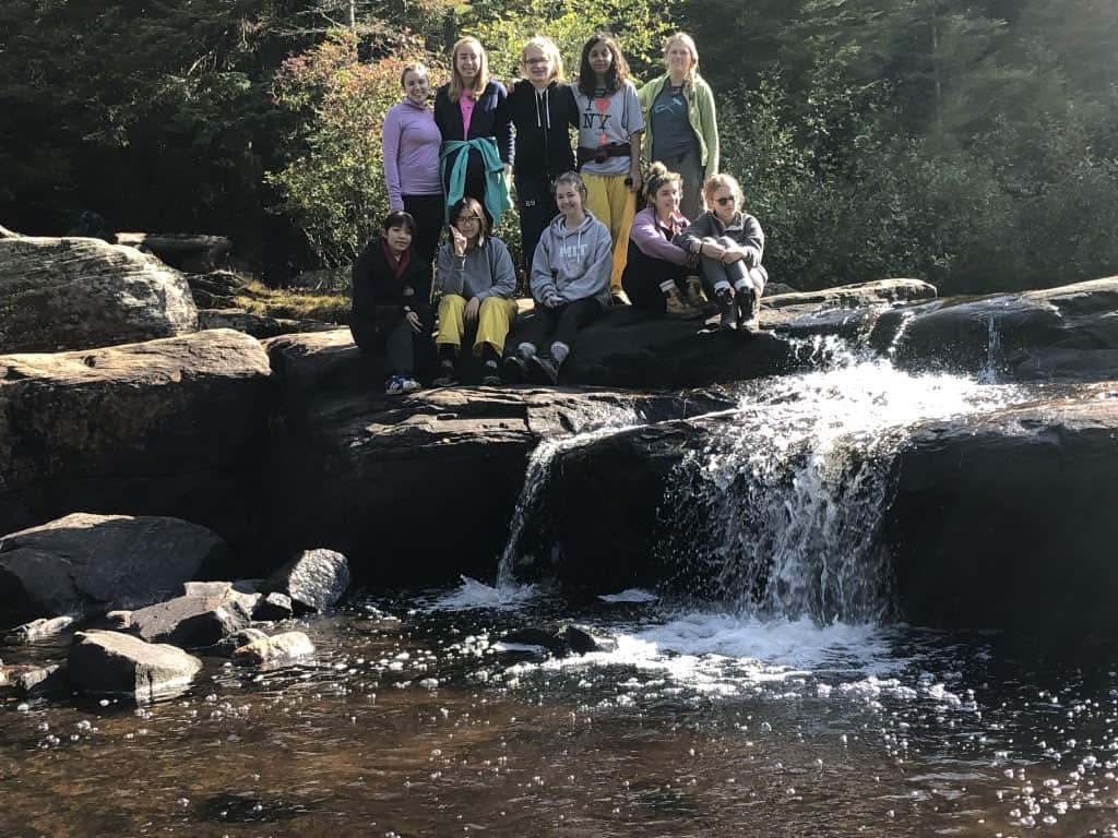 Group photo next to a waterfall during a Duke of Edinburgh fall hiking adventure