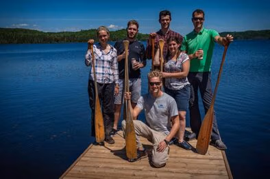 Group standing on the dock with paddles at algonquin Park