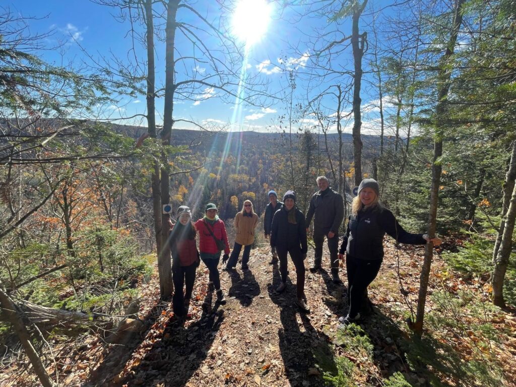 Wellness group on a hiking trail lookout above a valley of Algonquin fall colours